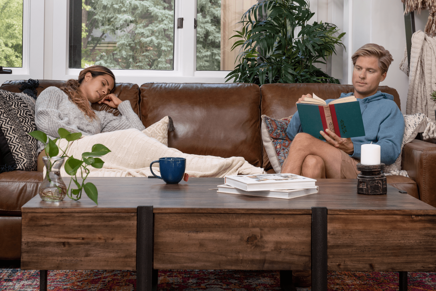 Room shot of chestnut brown leather sofa accompanied by wood and metal coffee table