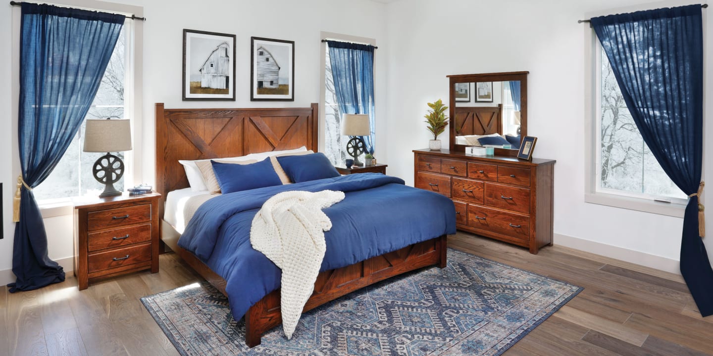 Rich wood bedroom set featuring a panel bed, nightstand, dresser, and wall mirror