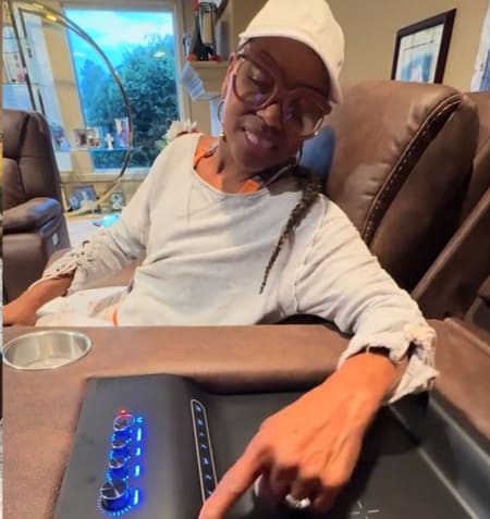 Brown Leather looking reclining sofa with controls panel in living room. Women pushing buttons.