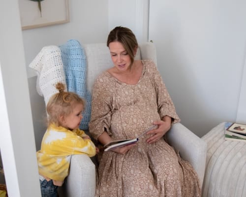 Mother reading to child in Mya Swivel Glider Recliner