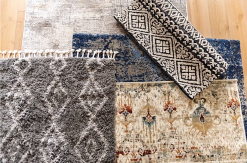 Collage of Rugs Overlaying each other on wooden floor