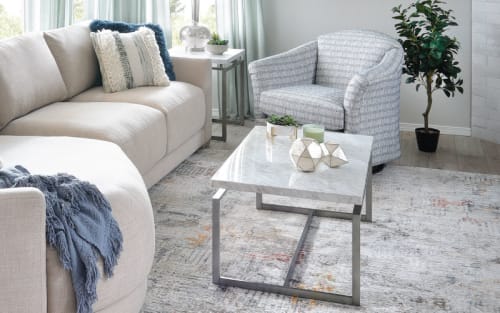 White sofa with matching chair, white marble coffee table and other minimalist decoratively styled products