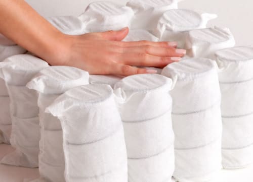 Hand Pressing down on Individually Wrapped Coils