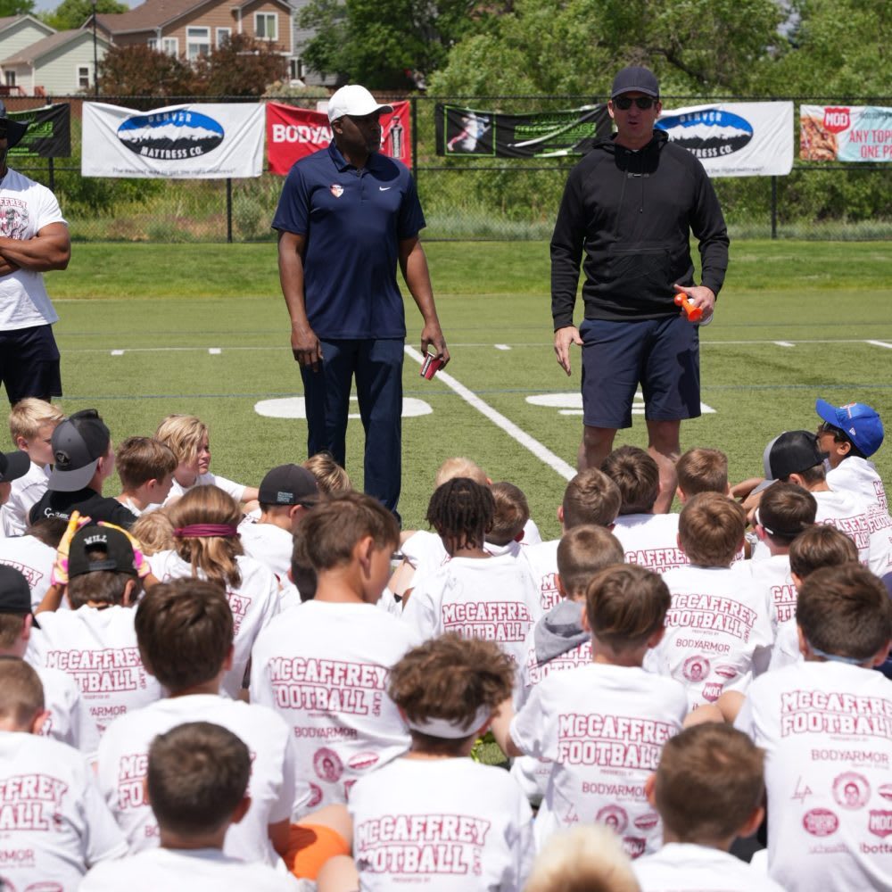 Ed McCaffrey and assistant coach at his football camp