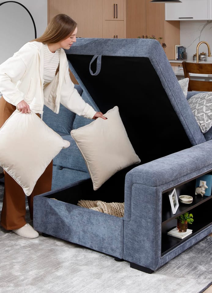Woman putting pillow in Blue microvelvet sectional with storage chaise