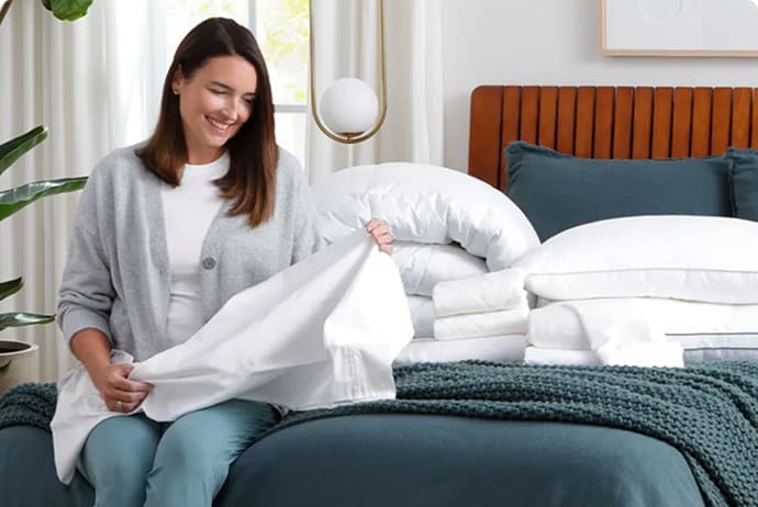 woman folding bedding accessories