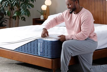 man fastening mattress protector on his mattress