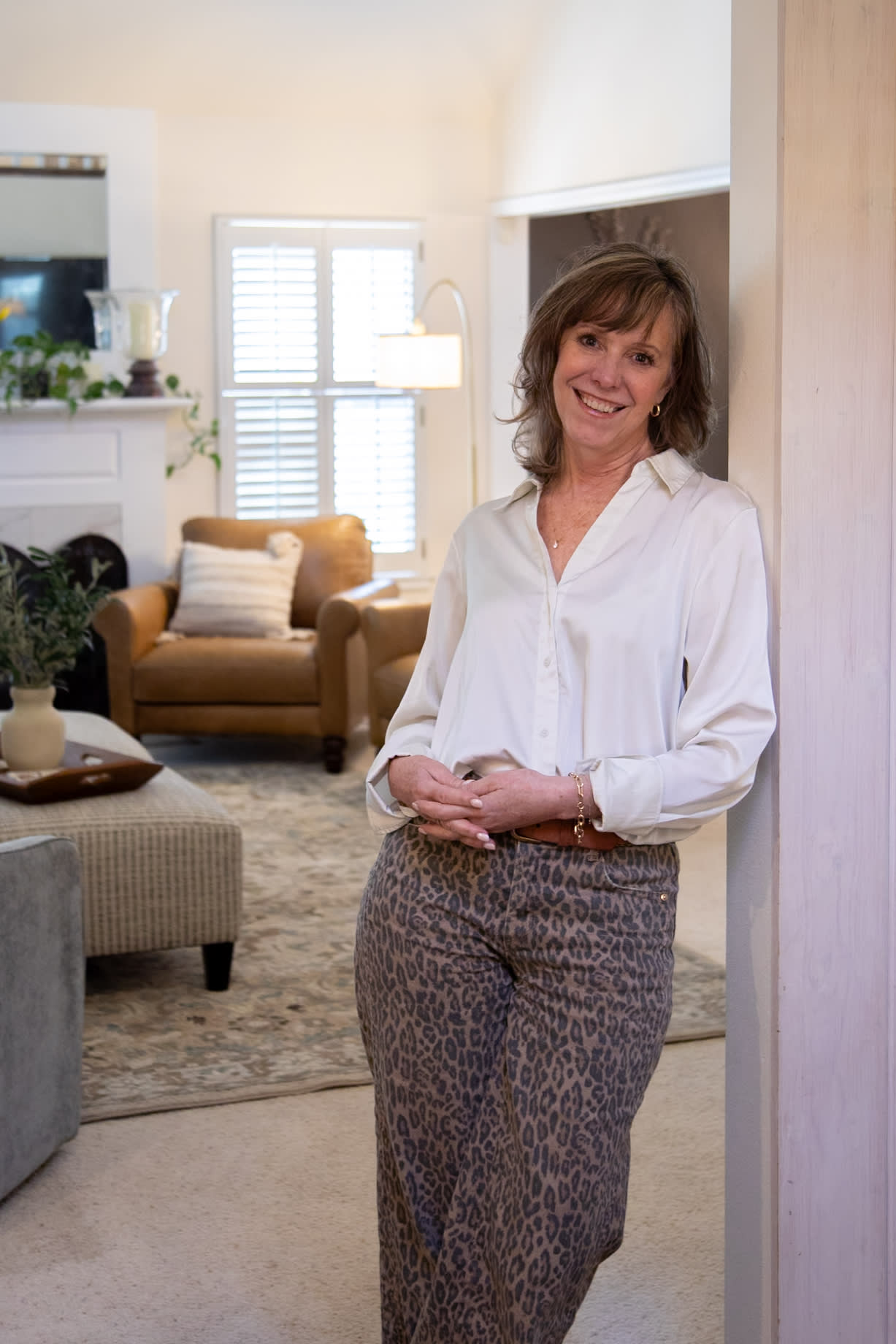 A profile shot of Any for real spaces, posed in front of the Laredo Chair styled in her home