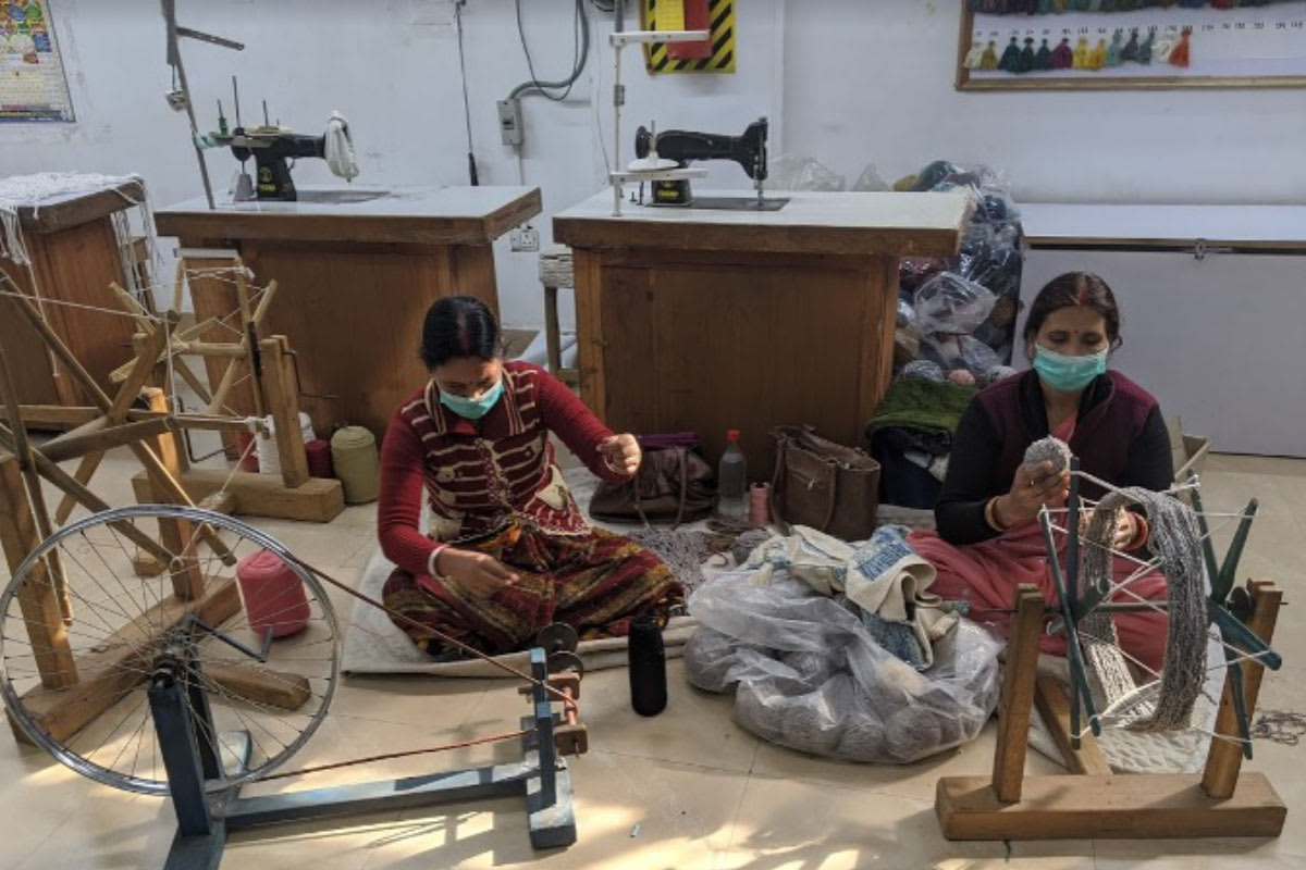 2 Women weaving yarn