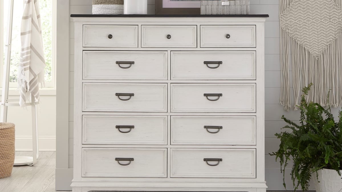 A white bedroom chest of drawers in a coastal-inspired bedroom