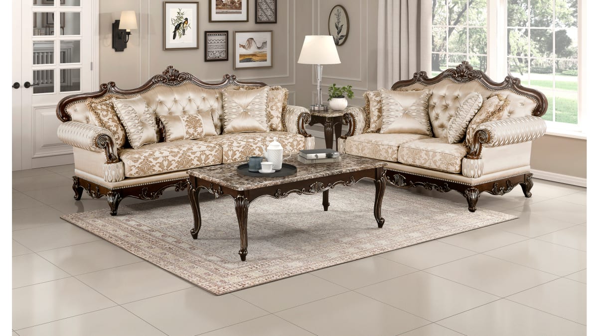 A rococo style couch and loveseat as well as a ornate coffee table in a living space
