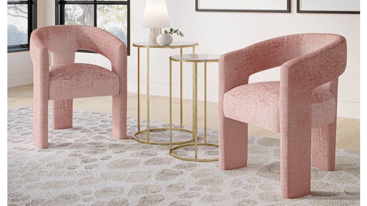 Two pink upholstered dining chairs serving as accent chairs with round side tables