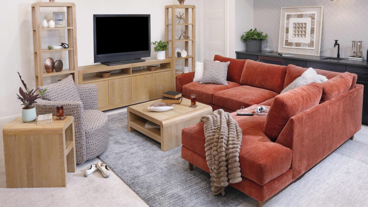 The red, paprika-colored Raine 2 Pc. Sectional in a contemporary living room with light wood tables