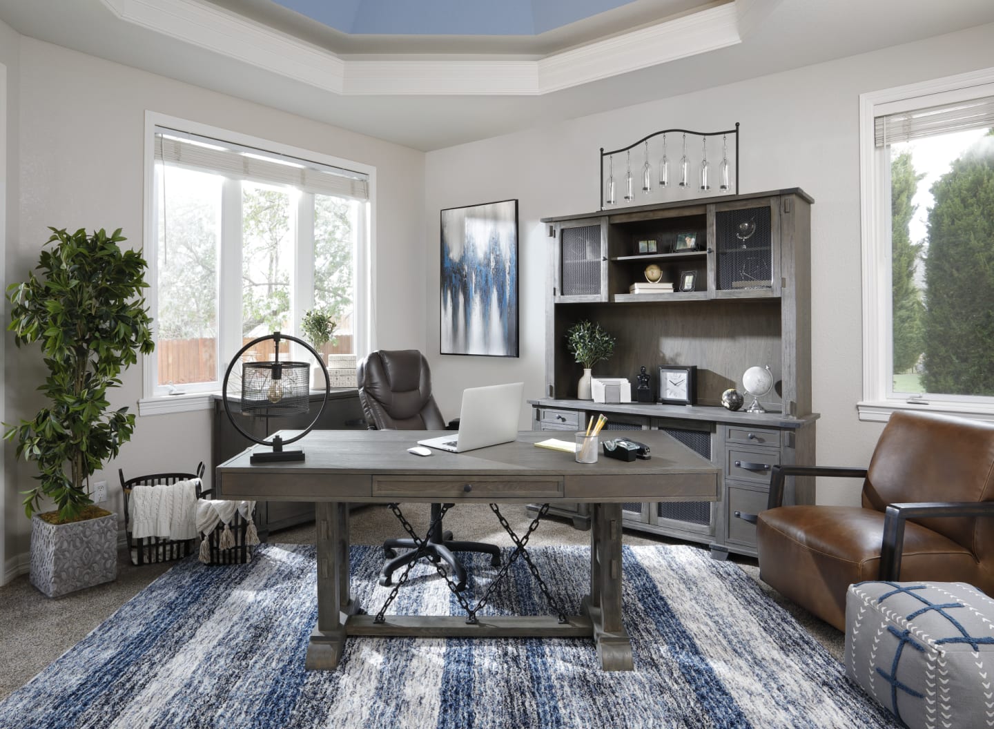 A wood writing desk with striking black chain link accents along its base in a contemporary home office