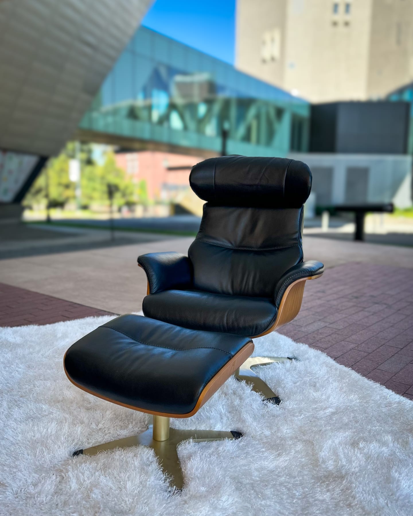 The Orbit Leather Swivel Chair and matching ottoman posed outside the Denver Art Museum