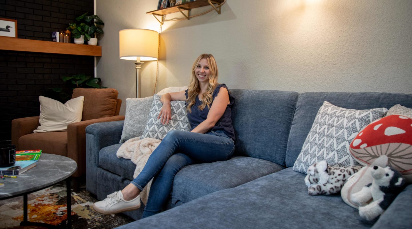 Kate sitting on the Noble Sectional styled for her modern living room