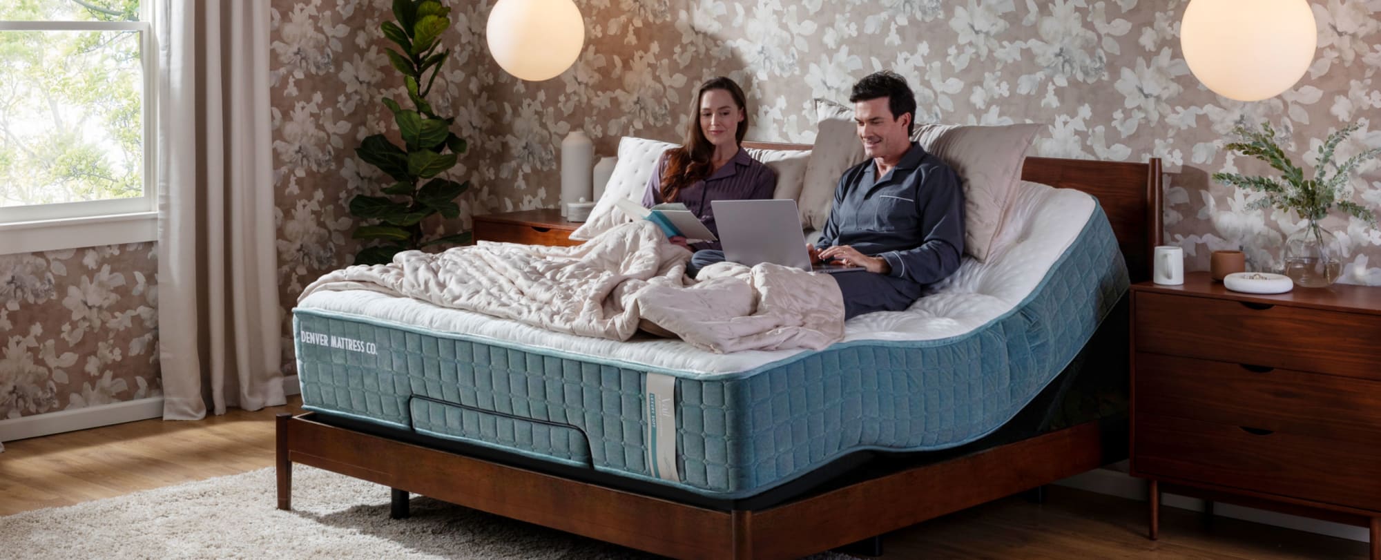 Couple Sitting on Mattress on Adjustable Base reading and on computer