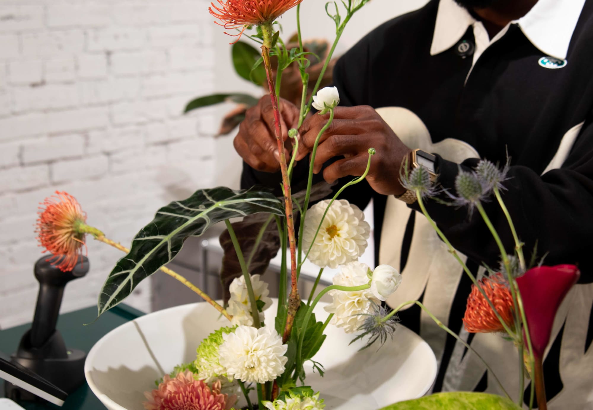 Closeup of ikebana with single flower stem in hand