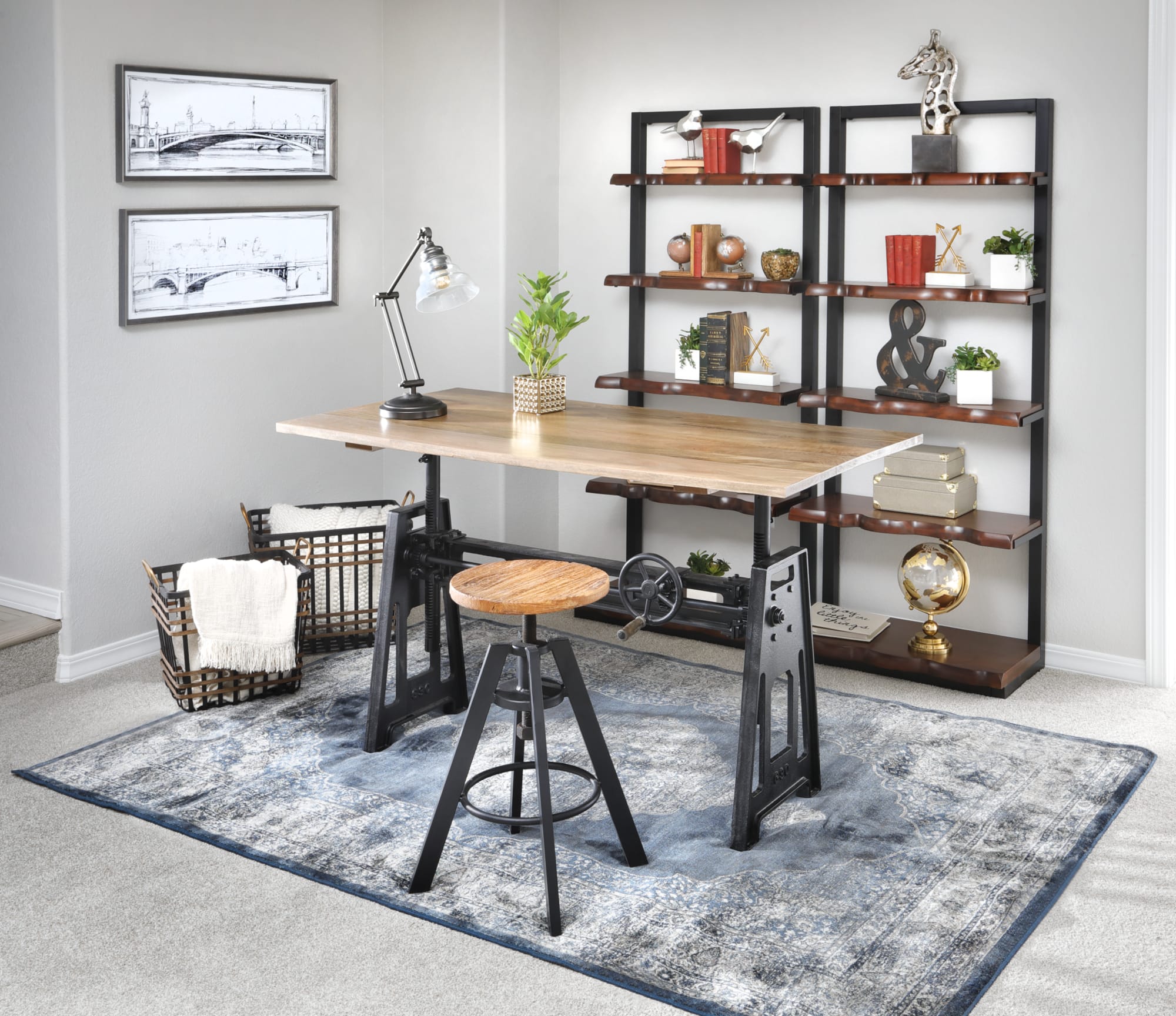 An adjustable standing desk and a backless stool with black metal bases and industrial style in a home office