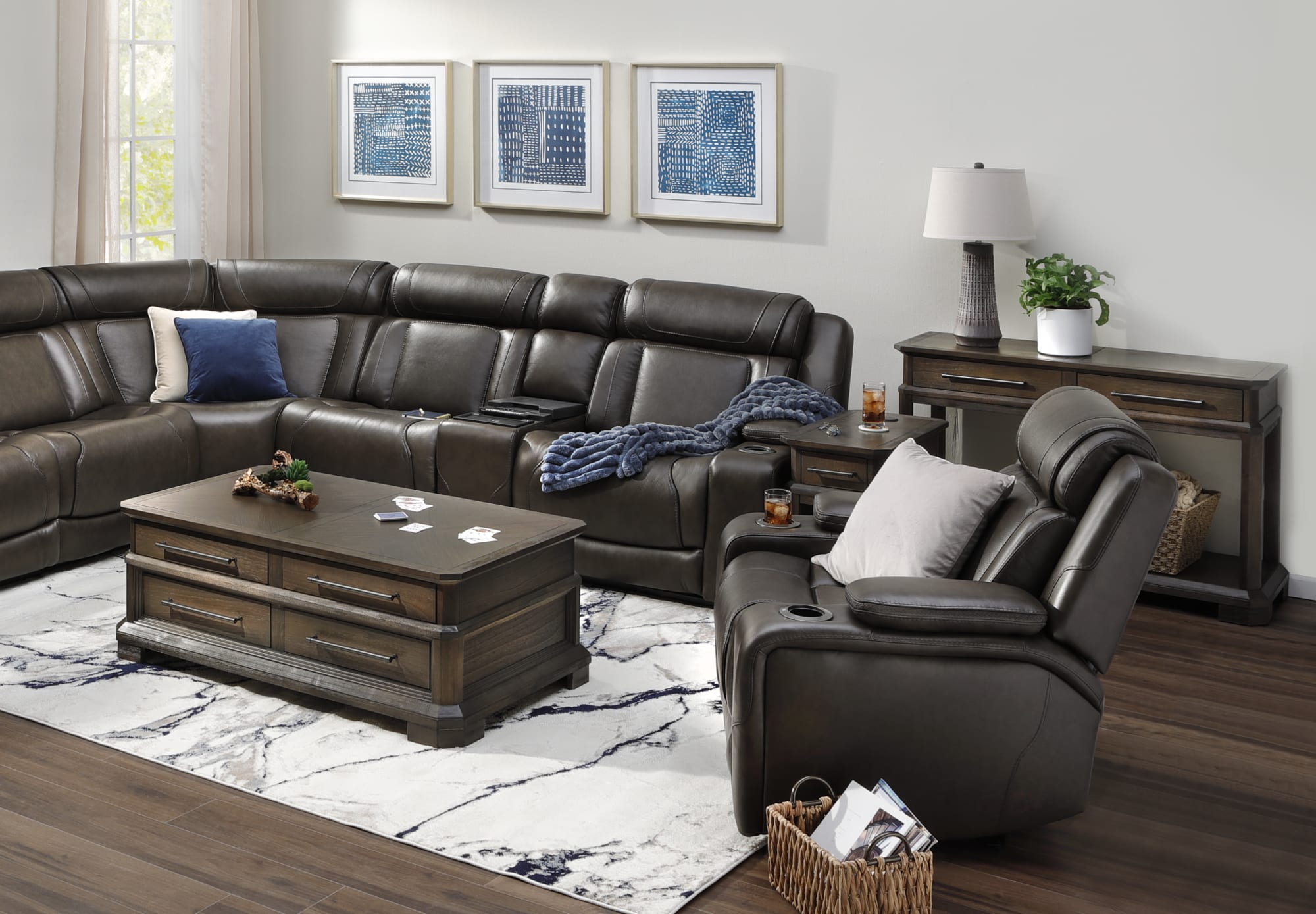 A dark brown leather power reclining sectional in a contemporary living room with a reclining chair and coffee table