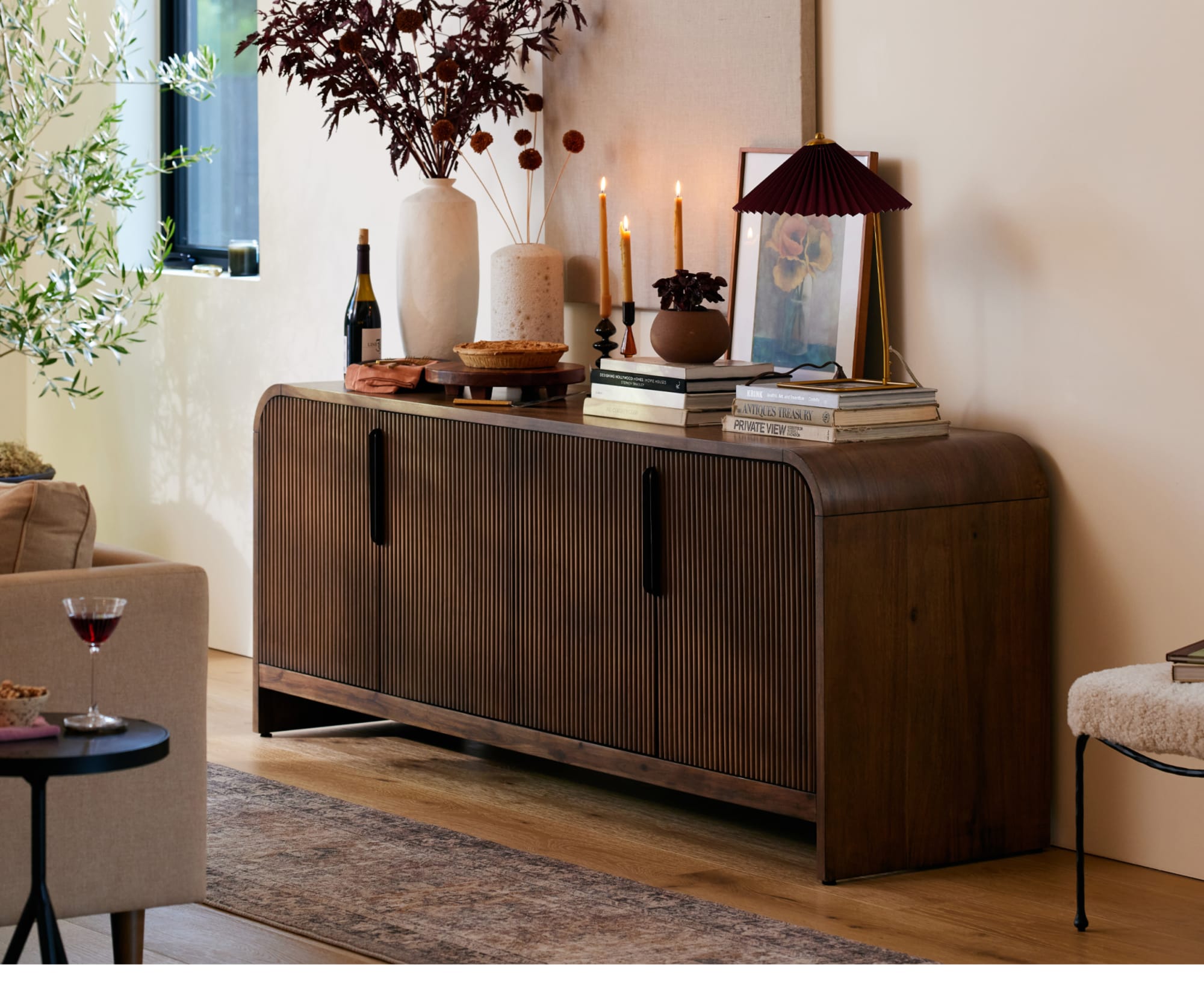 Room shot of the Adele Sideboard styled against a wall behind a sofa