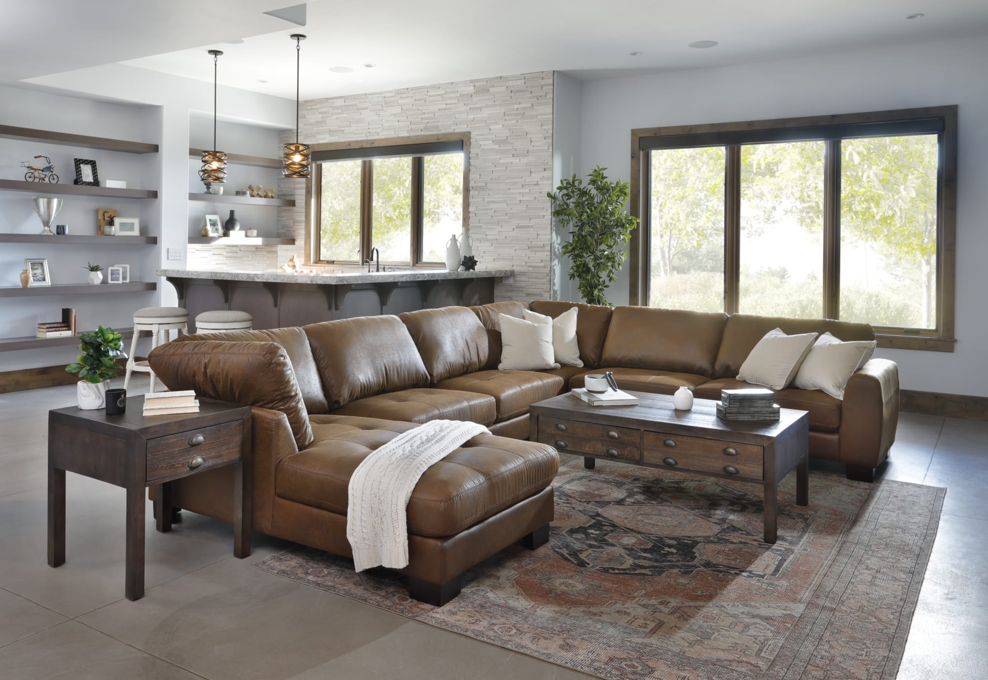 Brown leather chaise sectional with tufted seats around a coffee table