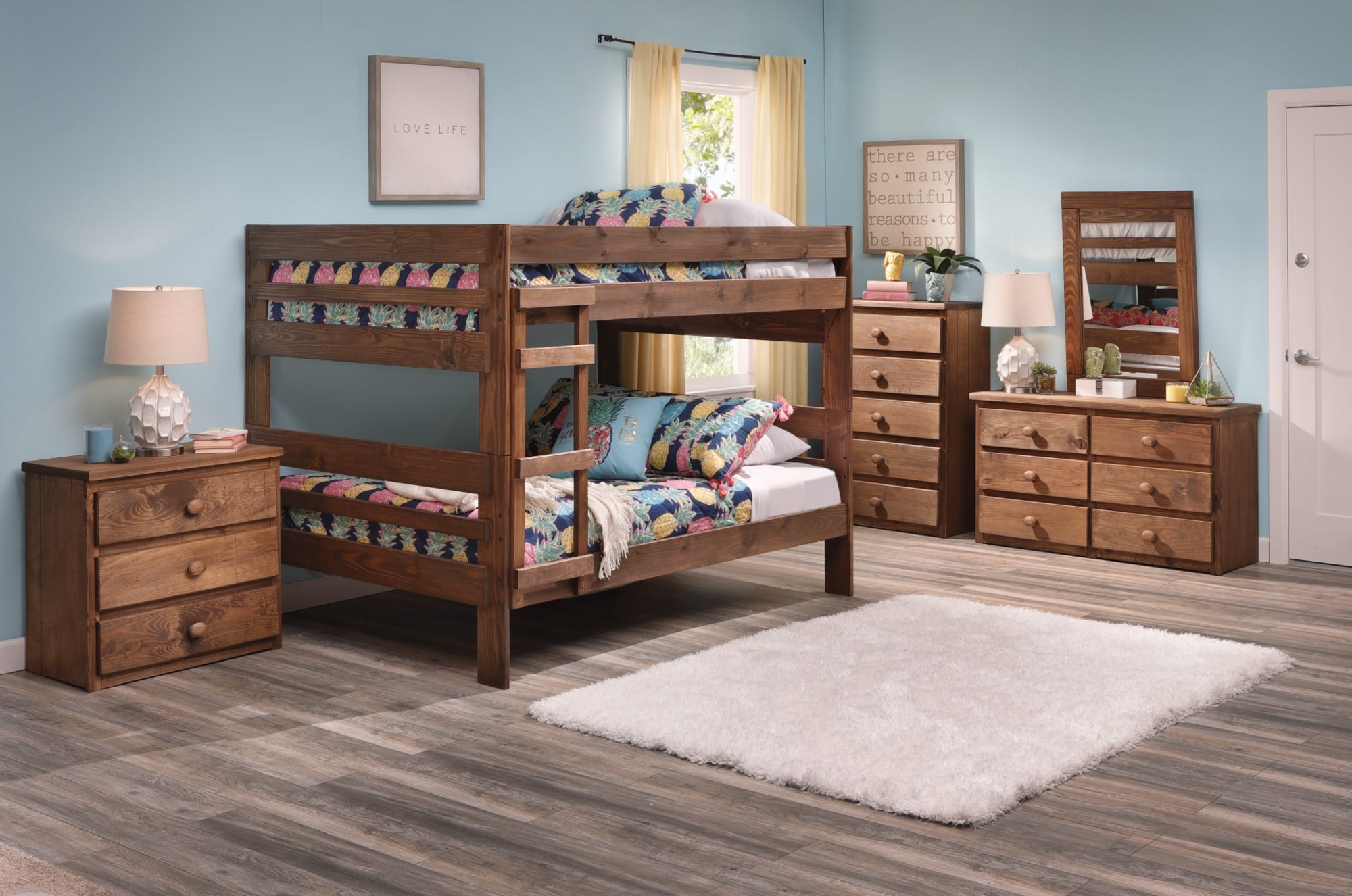 A wooden twin bunk bed accompanied by a nightstand, dresser, chest, and wall mirror