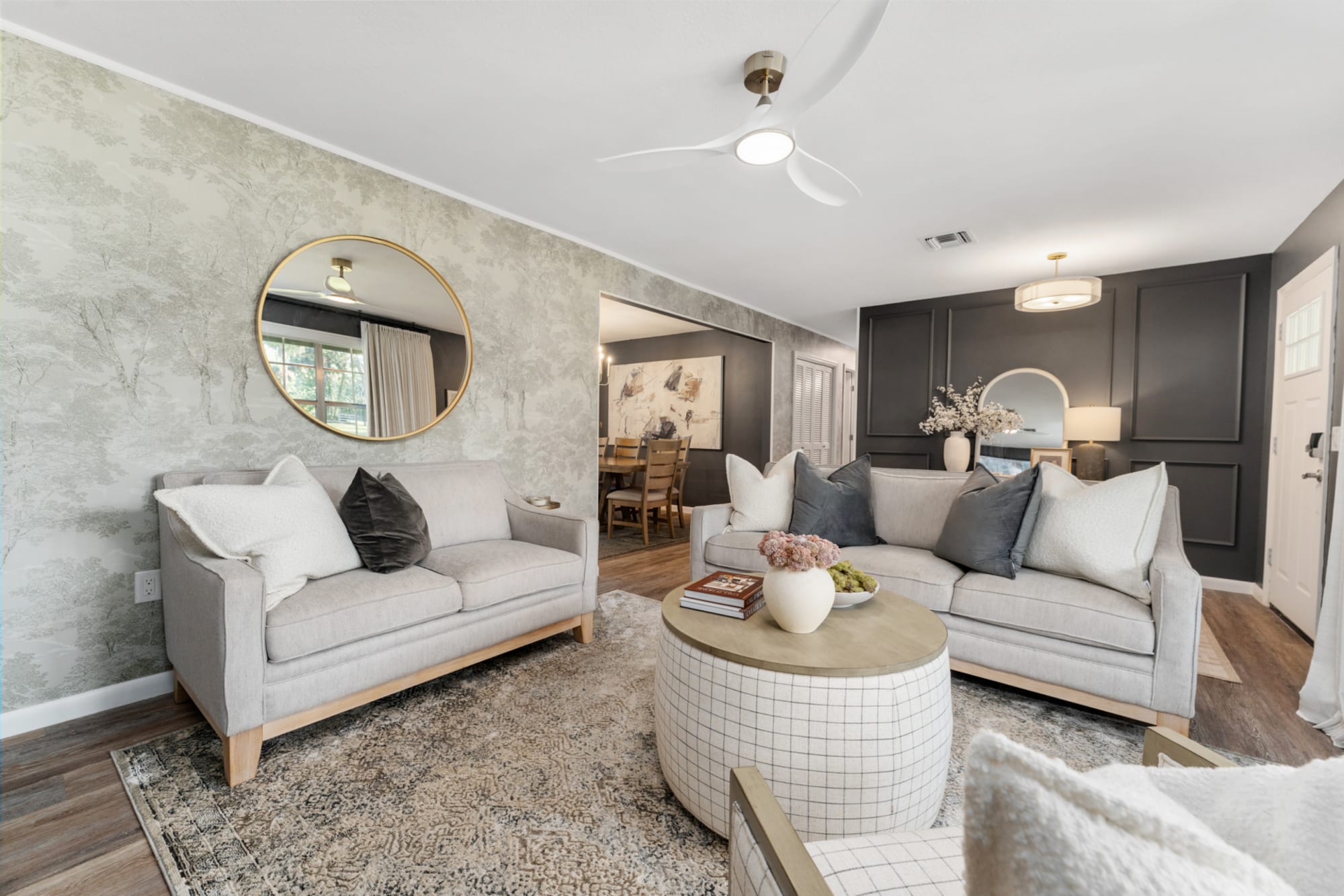 A light gray sofa and loveseat placed with a white coastal coffee table in Kelli Bateman's Airbnb