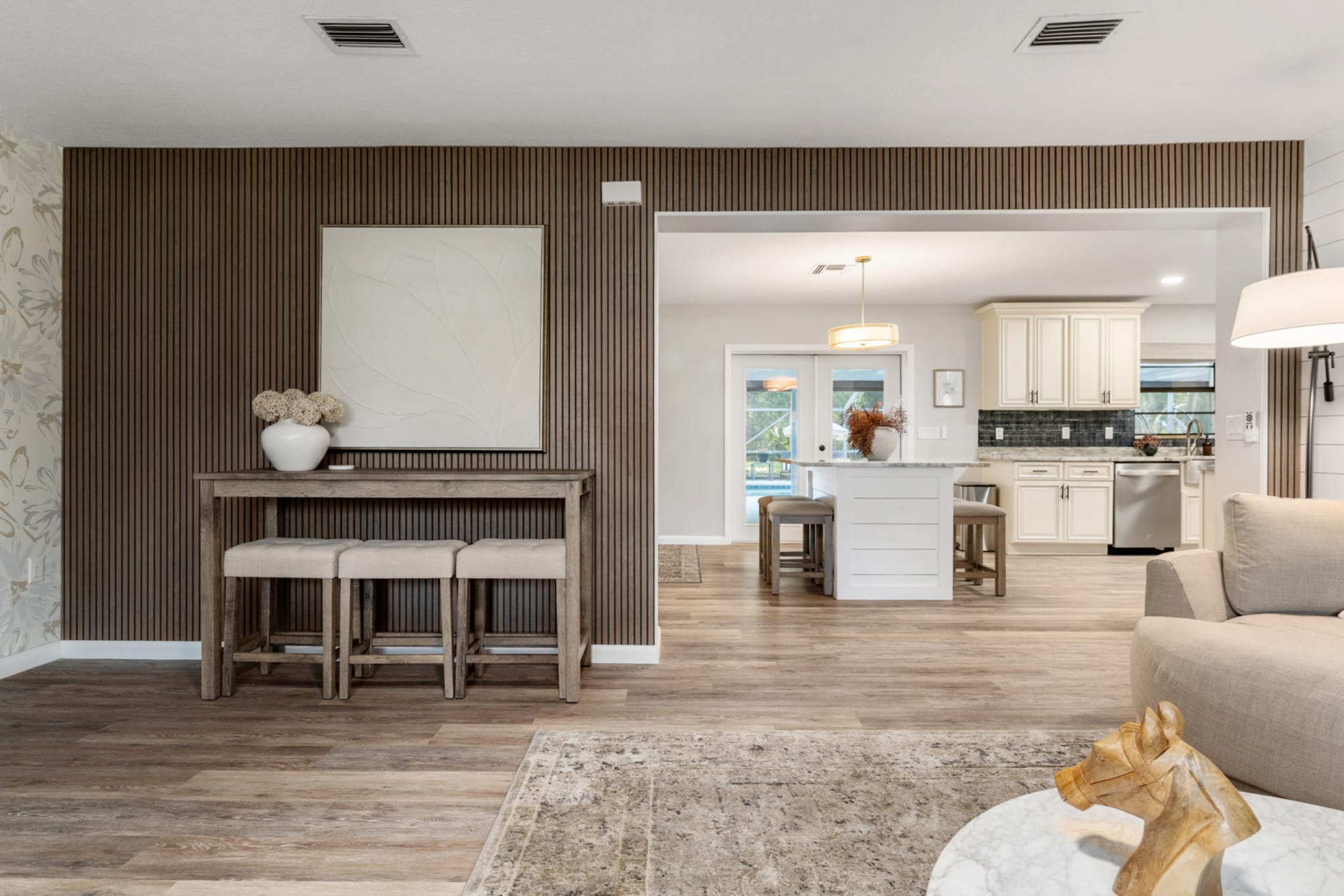 Rustic wood bar table set with three stools in Kelli Bateman's Airbnb living room