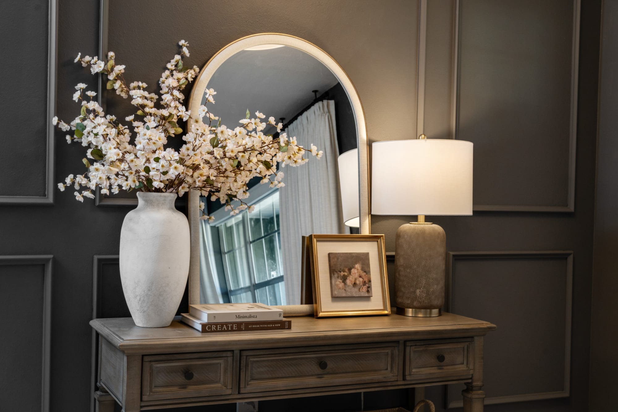 Entryway table with mirror and neutral decor in Kelli Bateman's Airbnb front entry