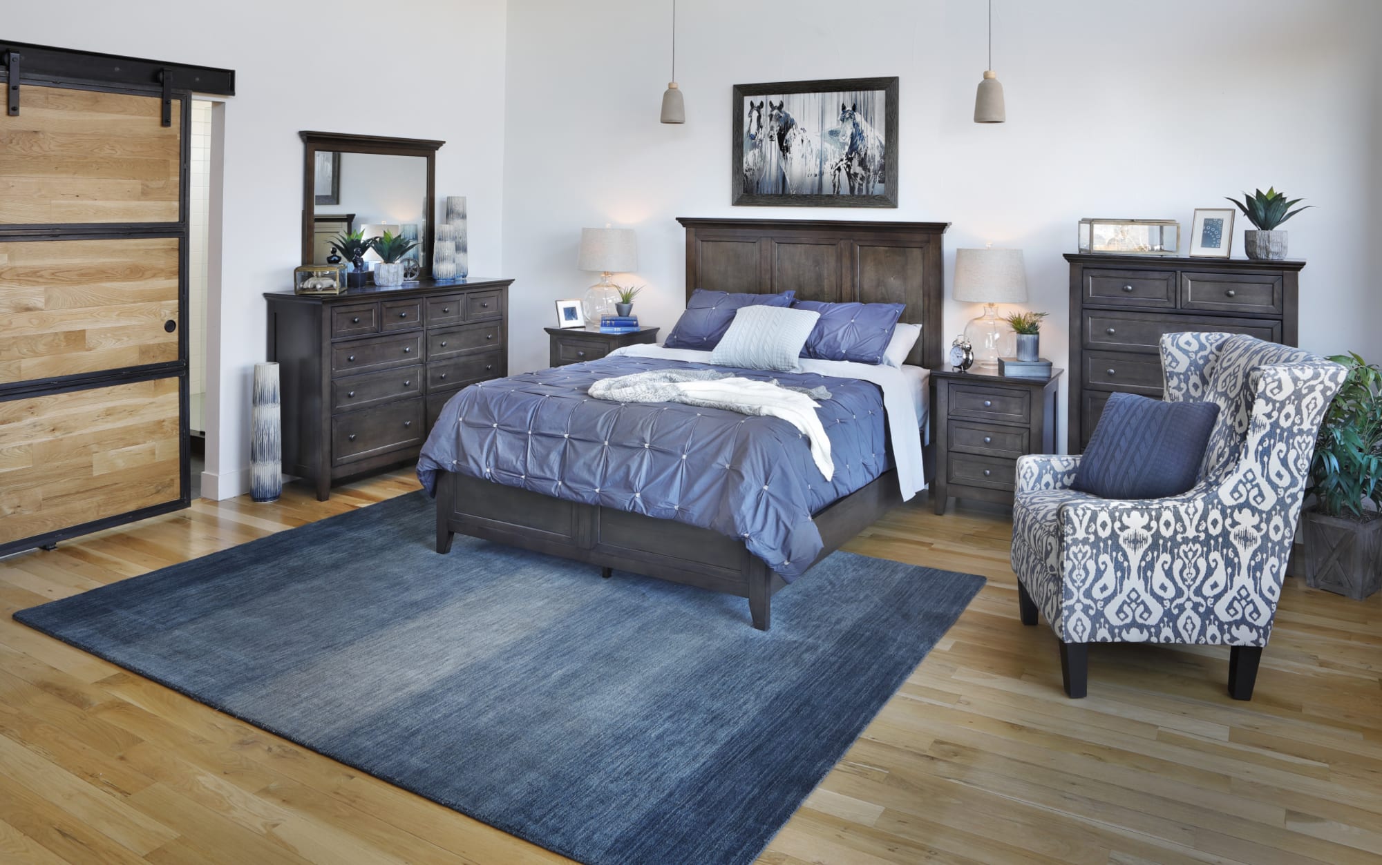 A bedroom featuring a wood bedroom set and a blue accent chair