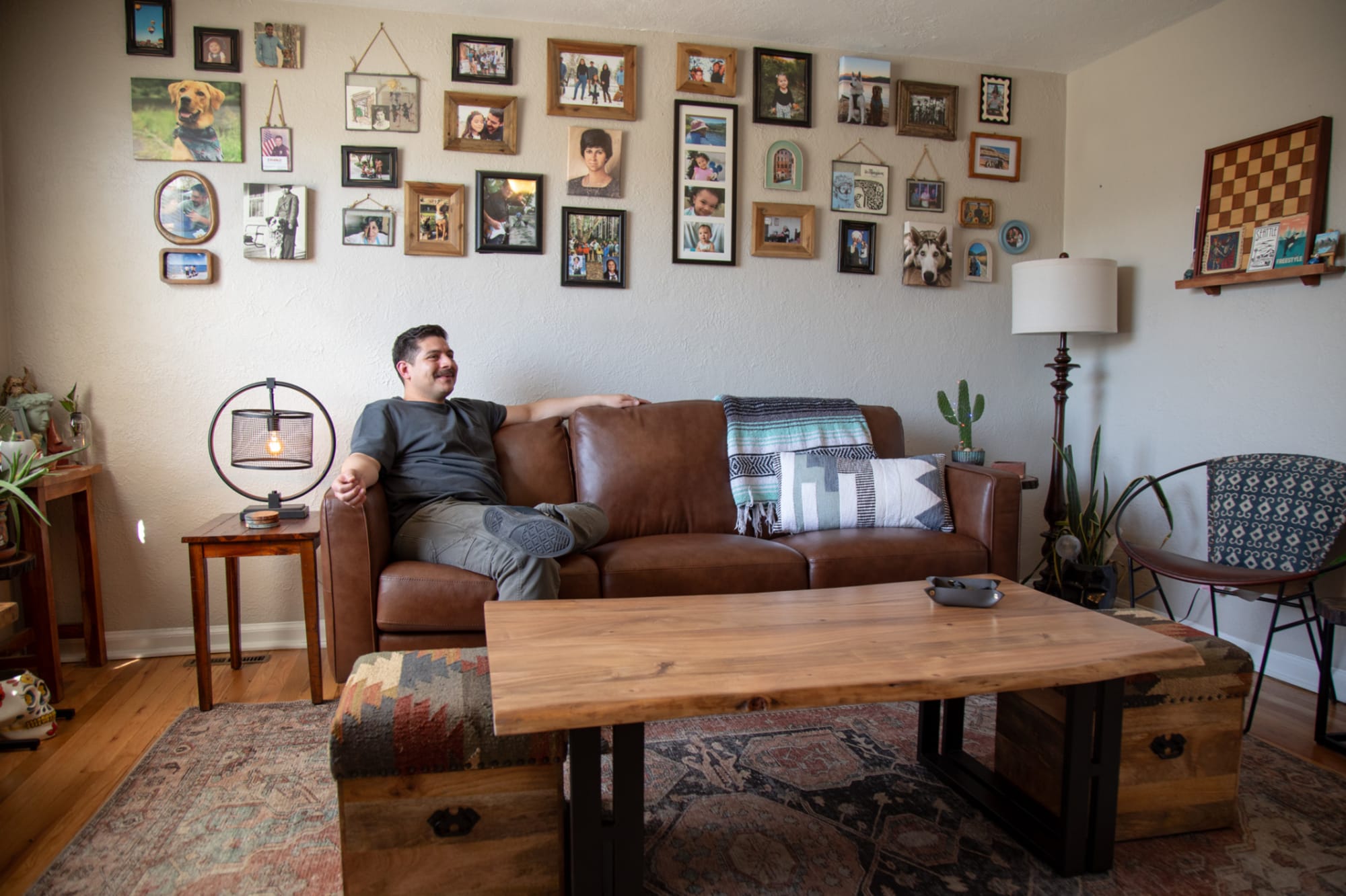 An image of Real Spaces host, Dakota, sitting on a leather sofa in his living room