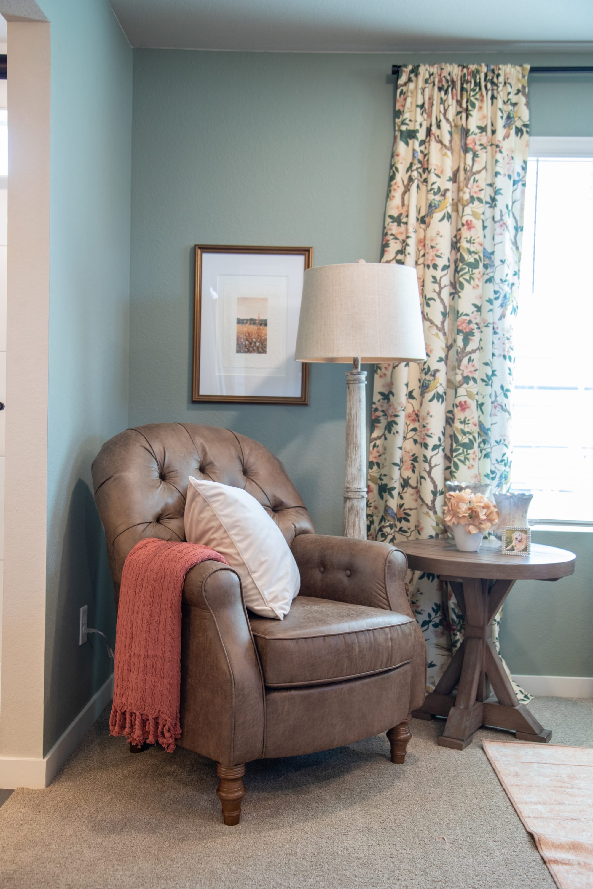 The Book Nook Accent Chair in a bedroom corner with round end table
