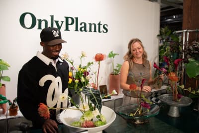 People admiring ikebana flower arrangements