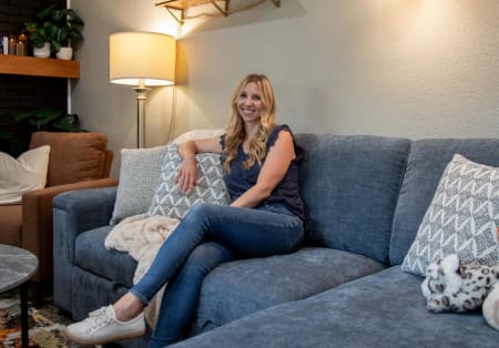 Kate sitting on the Noble Sectional styled for her modern living room
