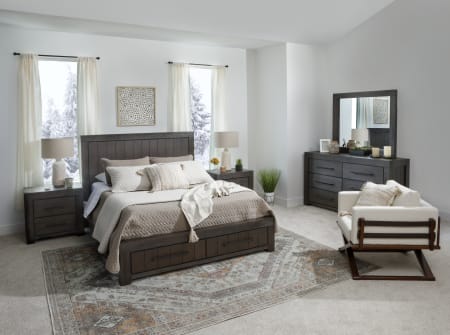 Modern, dark wood storage bed with accompanying dresser, mirror, and beside tables shot in a bedroom window scene