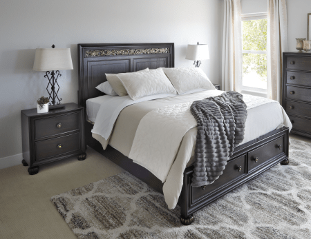 Deep brown traditional style bed with footboard storage accompanied by nightstands in bedroom window scene