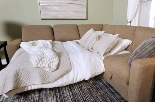 Cafe Brown Sectional with Sleeper portion made up as a bed