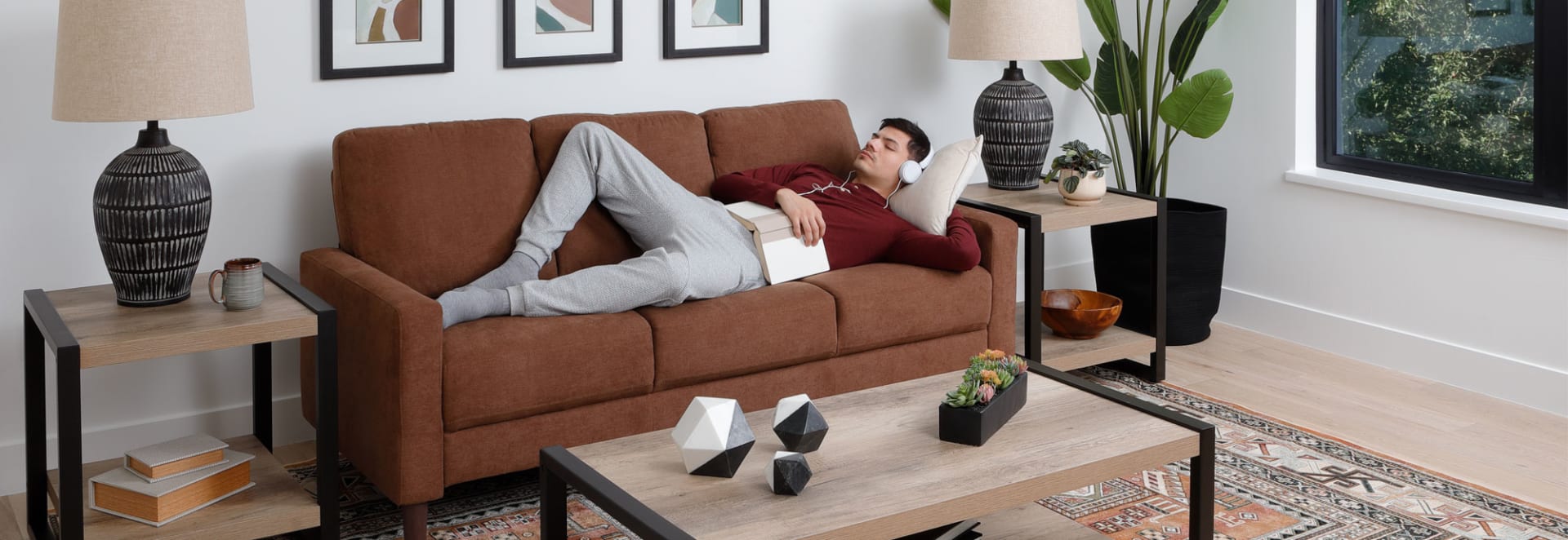 College Student Sleeping on copper colored Sofa with book on chest.
