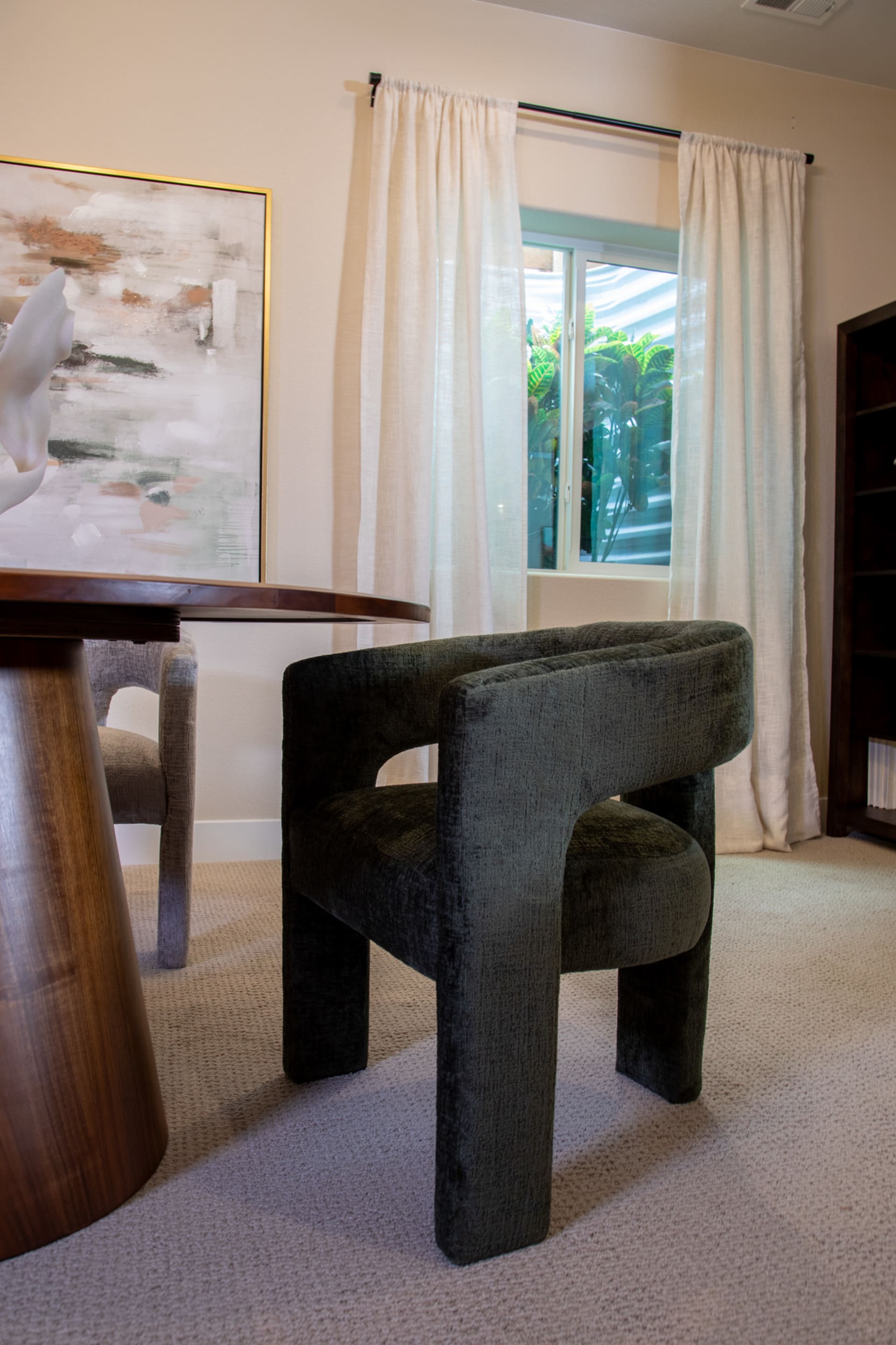The green Nash Dining Chair at a round table
