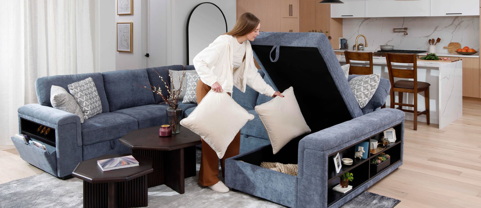Woman putting pillows in Blue Fabric Storage Sectional