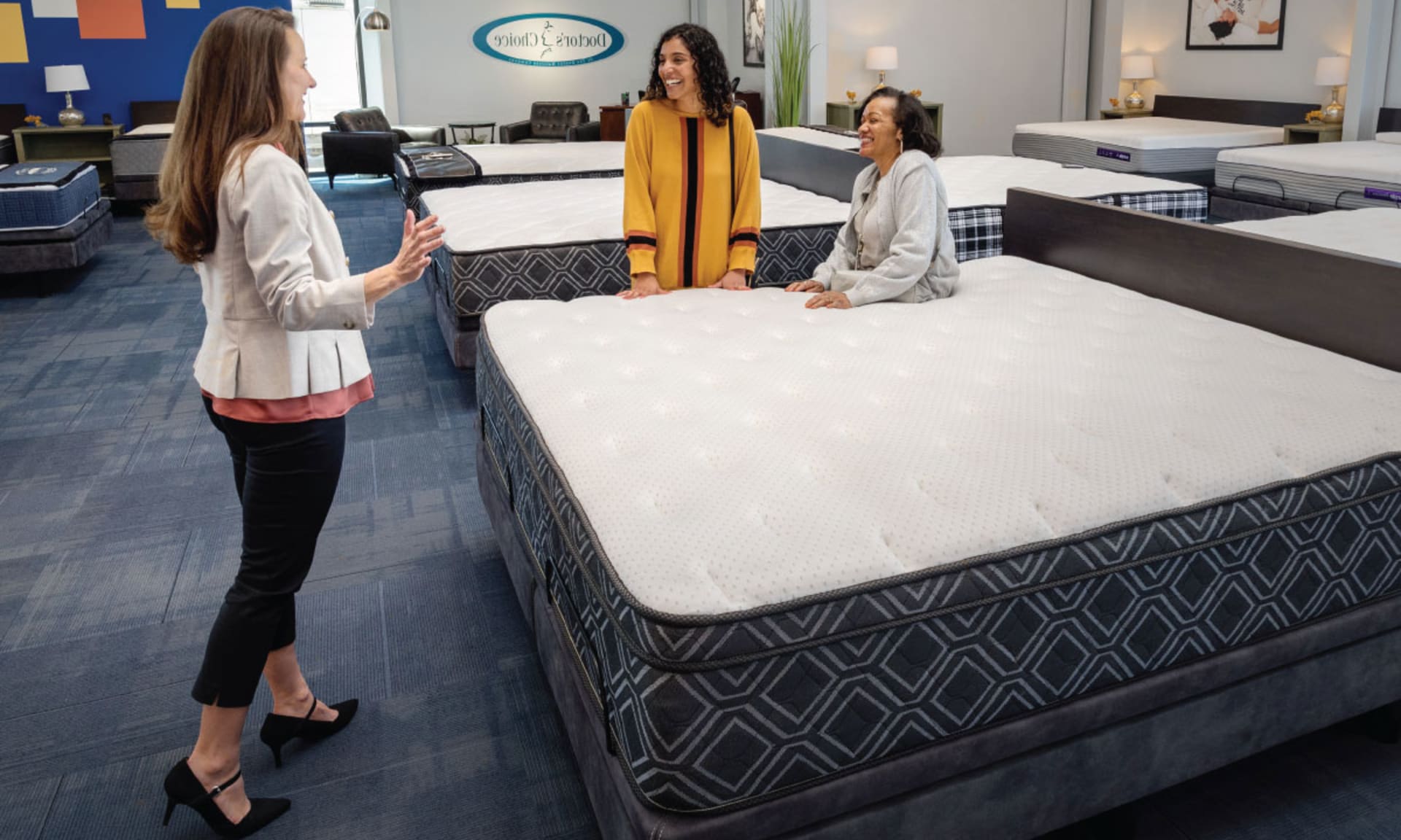 Sales Person with Customers Sitting on Mattress at Denver Mattress Store