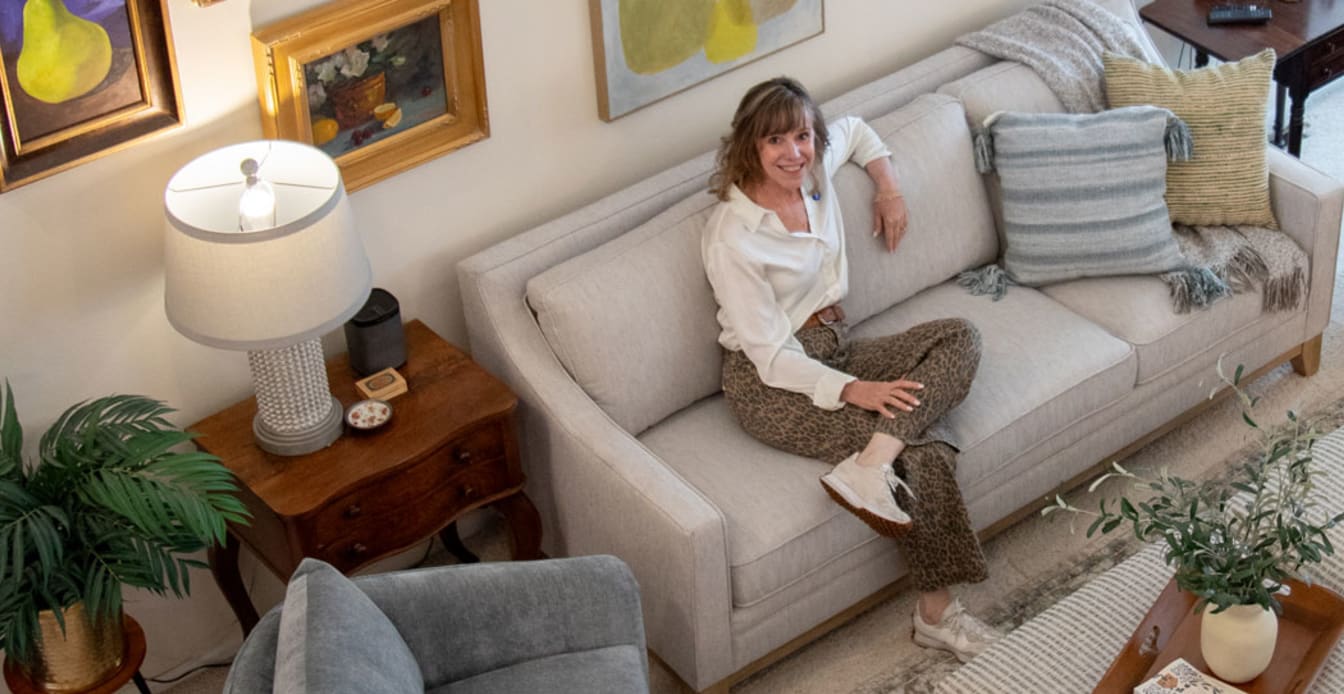 Woman Sitting Gray Sofa in Living Room under Gallery Wall