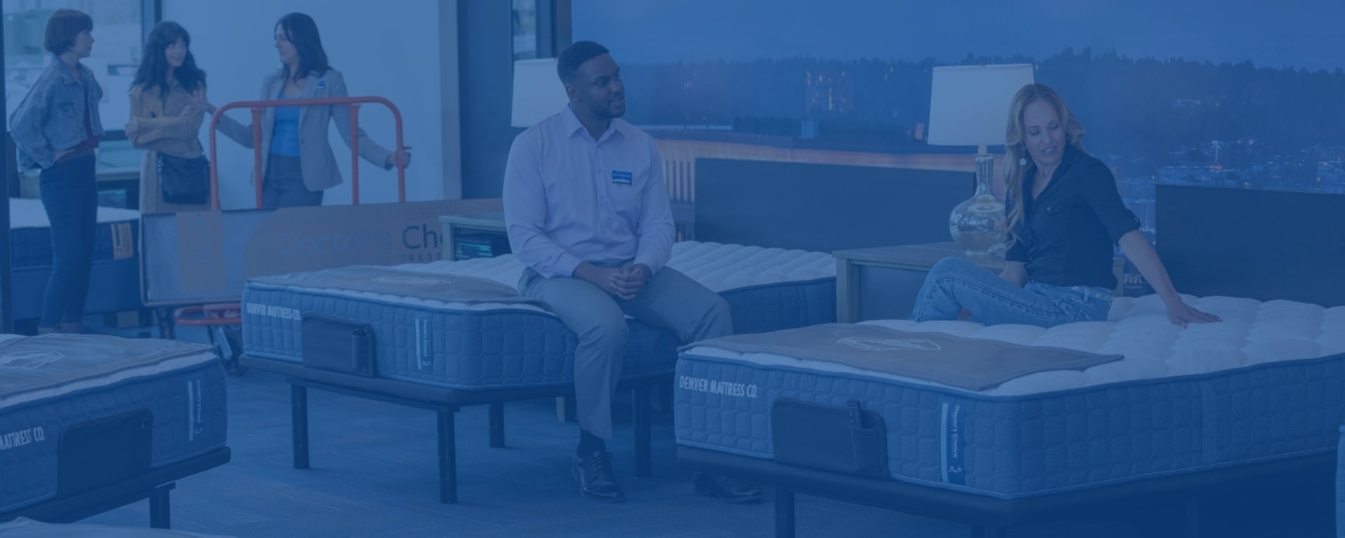 Denver Mattress employee helps woman find mattress in store.
