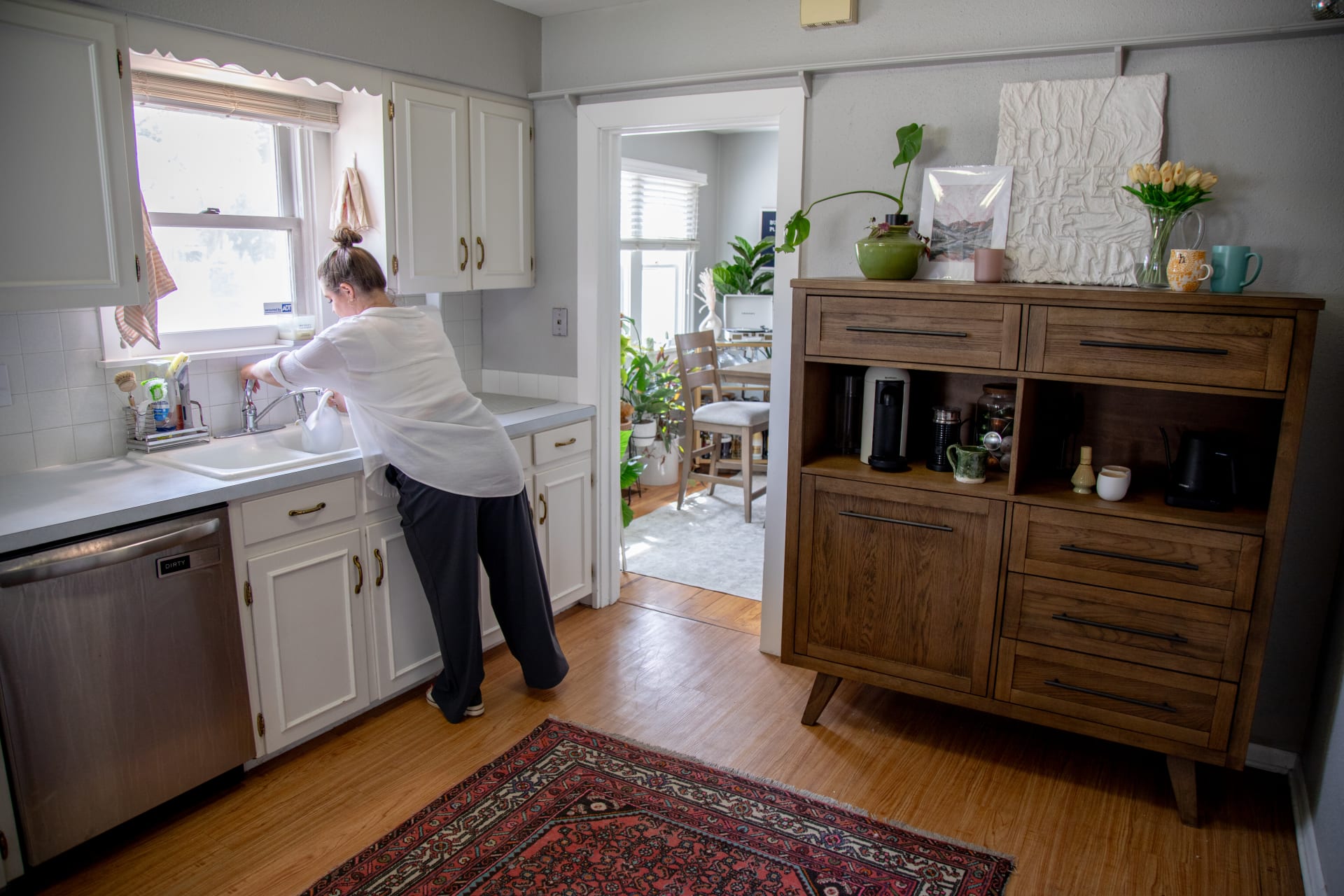 A tall wood dining server with open cabinets in a kitchen
