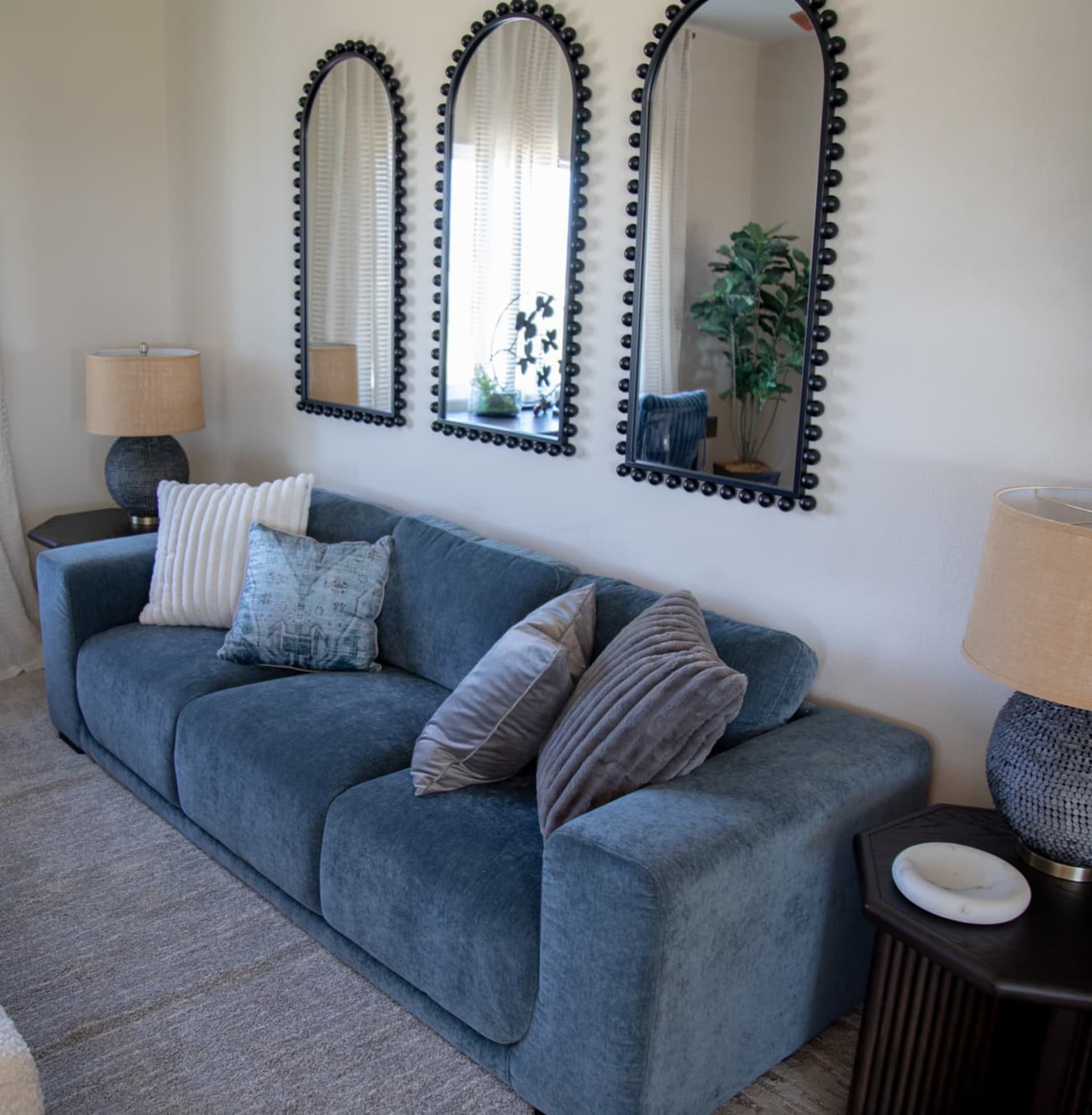 Room shot of Jasper Sofa with two end tables, table lamps, and a tri mirror wall accent