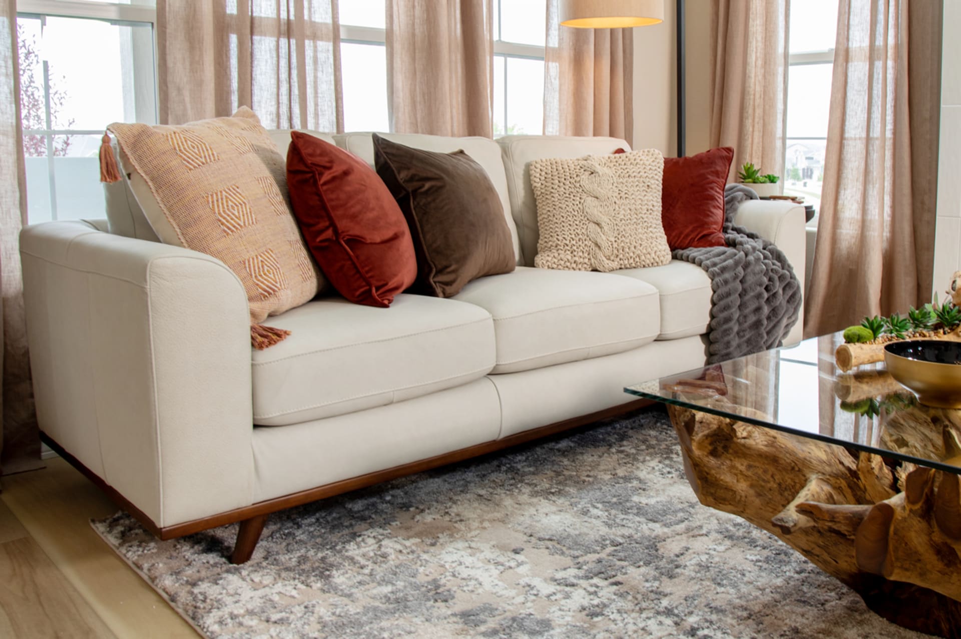 White Leather Sofa with Wooden legs in Organic Modern Living Room with Red Tones