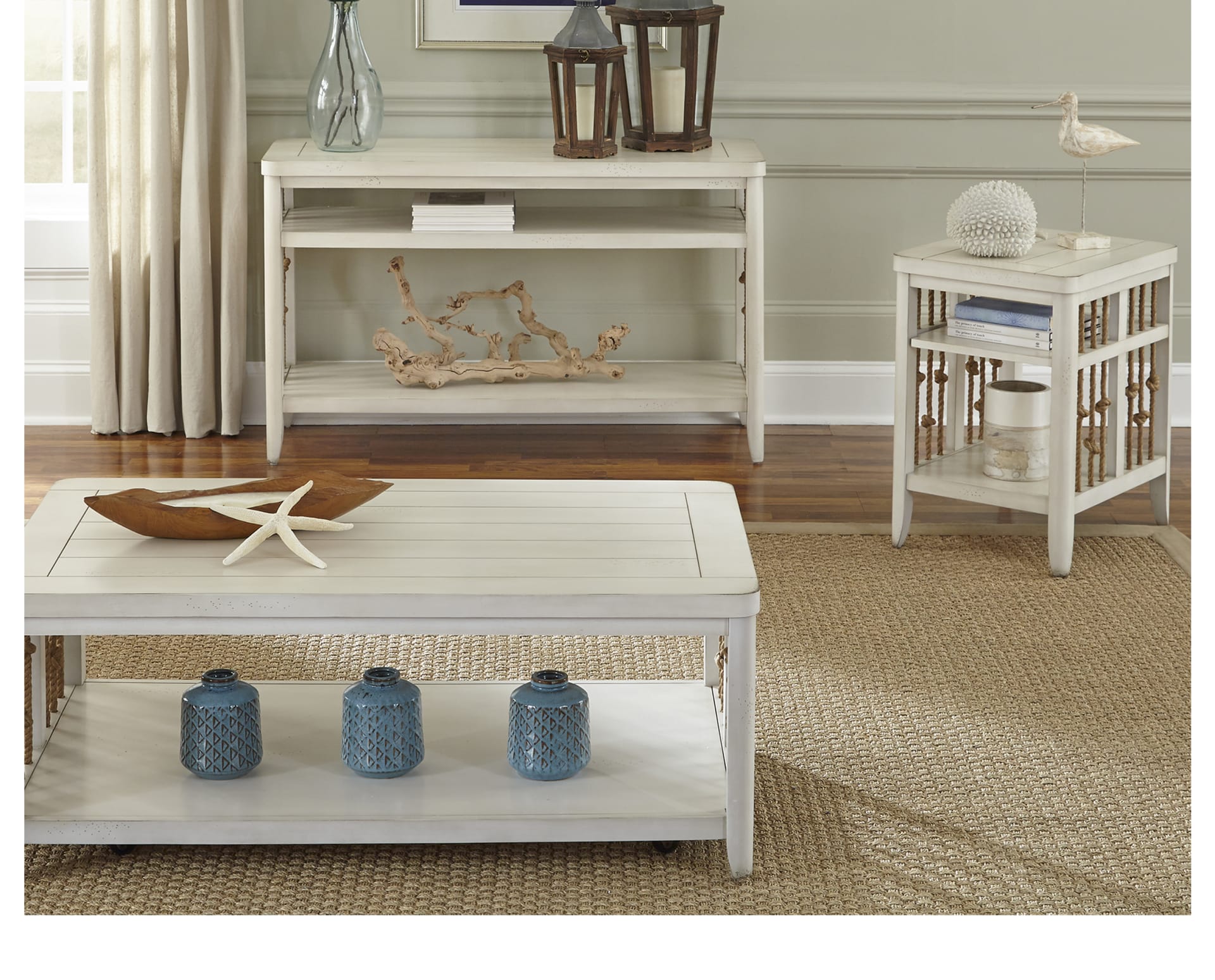 A white wood coffee table, end table, and sofa table set with rope accents and coastal decor