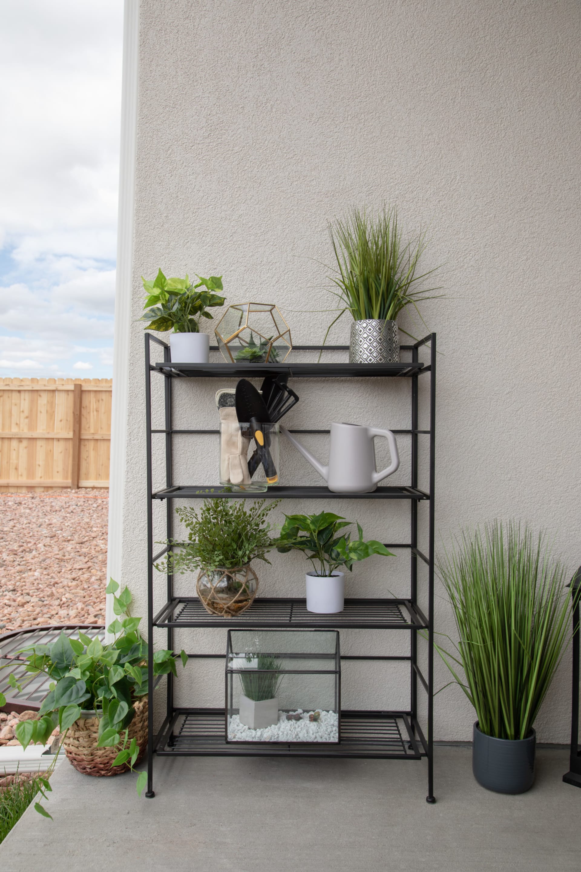 Outdoor shot of a metal shelf holding various plants