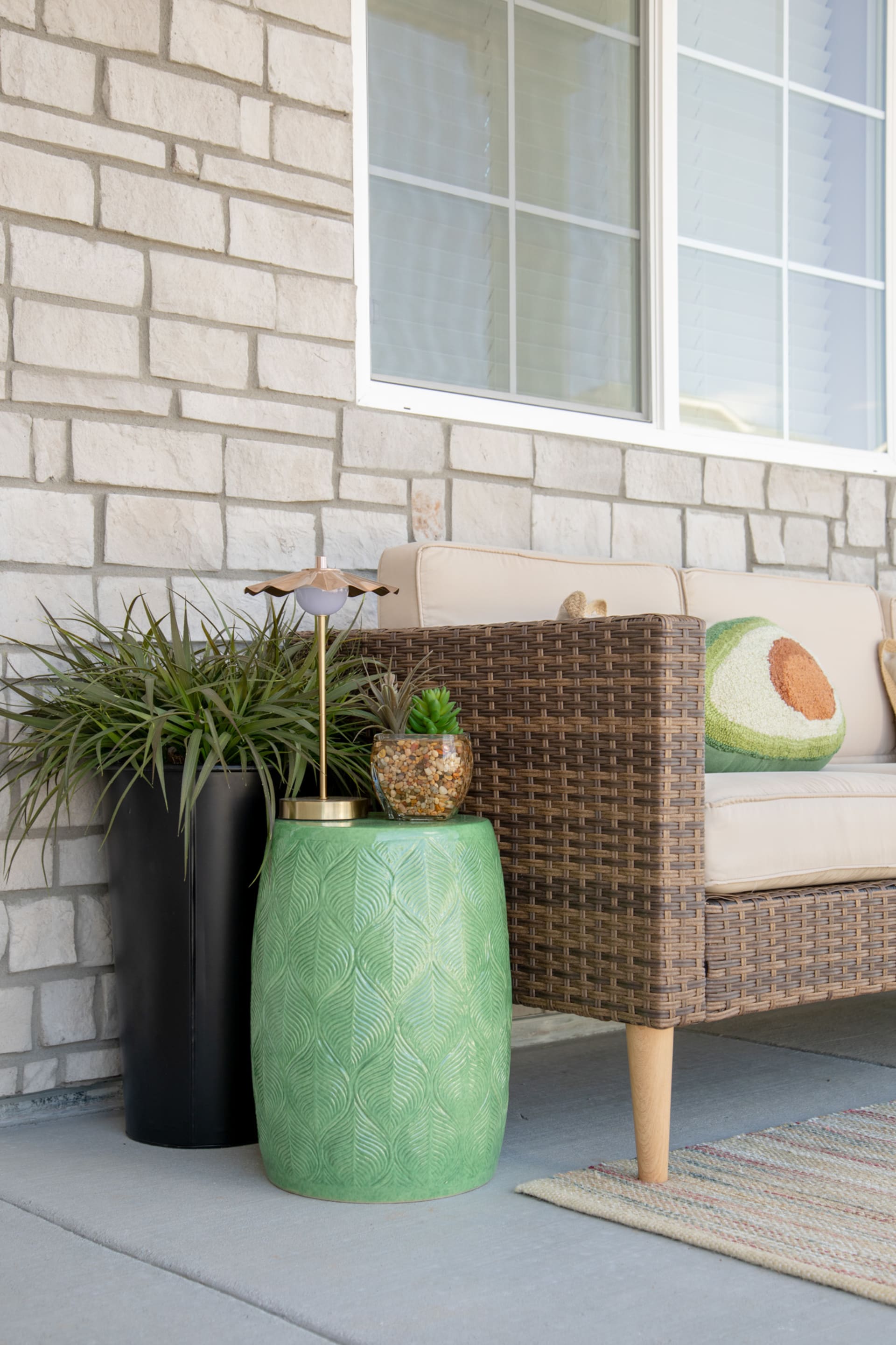 The San Bruno 4 Pc. Patio Set styled on a front porch with a green end table and large planter